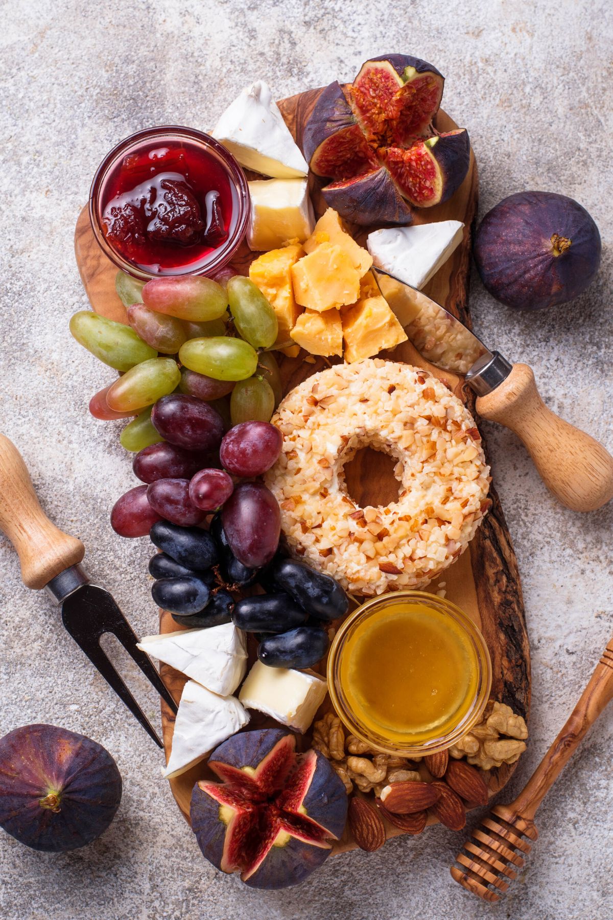 Cheeseboard with grapes, figs, and jam.