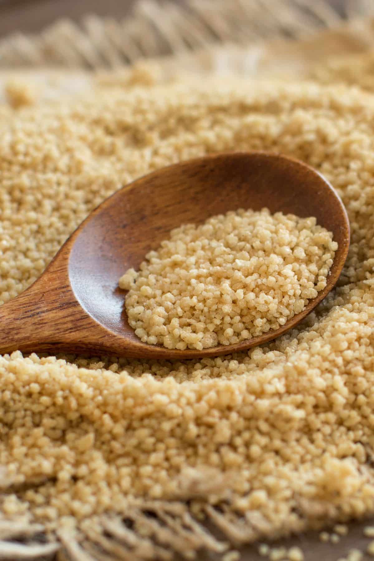 Scoop of couscous on tabletop surface.