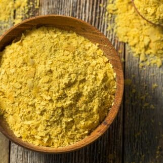 Bowl of nutritional yeast on wooden surface