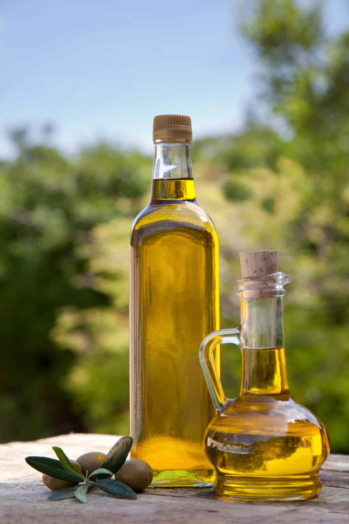 Jars of olive oil on wooden surface.