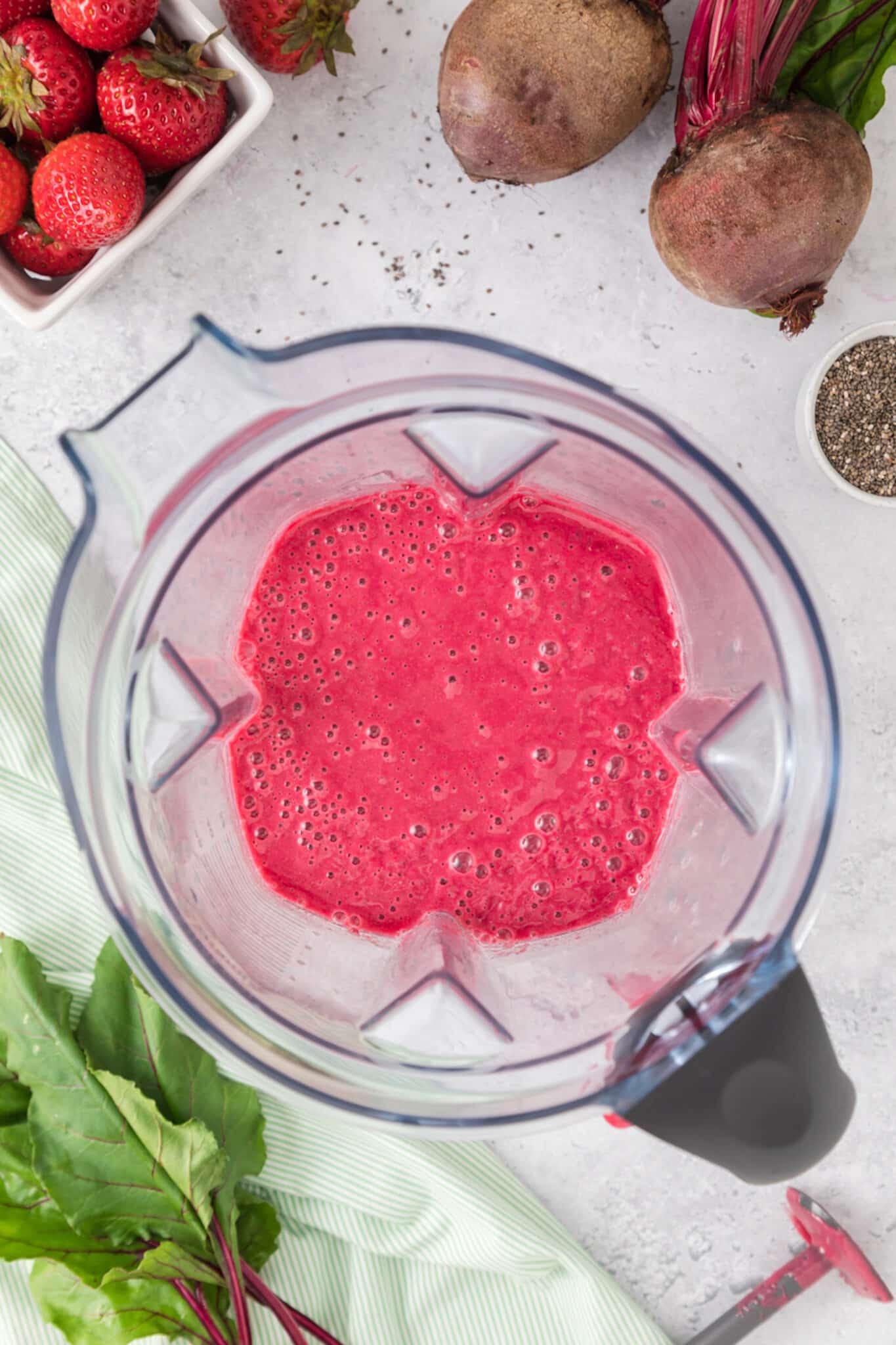 Top view of a strawberry smoothie in the jar of a blender.