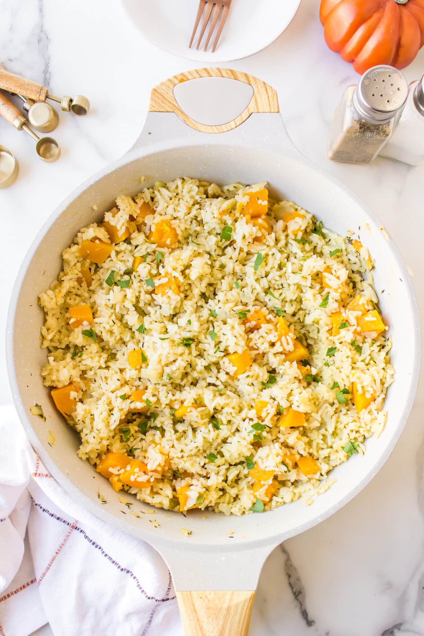 A white stockpot filled with cooked pumpkin rice.