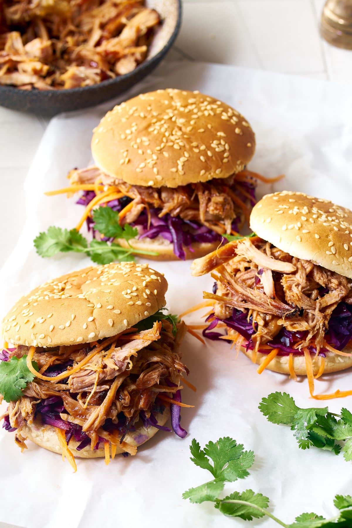 Pulled pork sandwiches on a white surface.