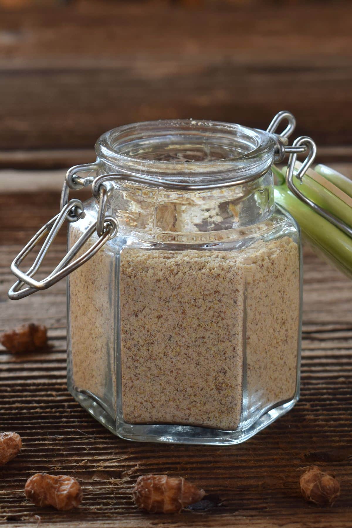 Jar of tigernut flour on wooden surface with tigernuts.