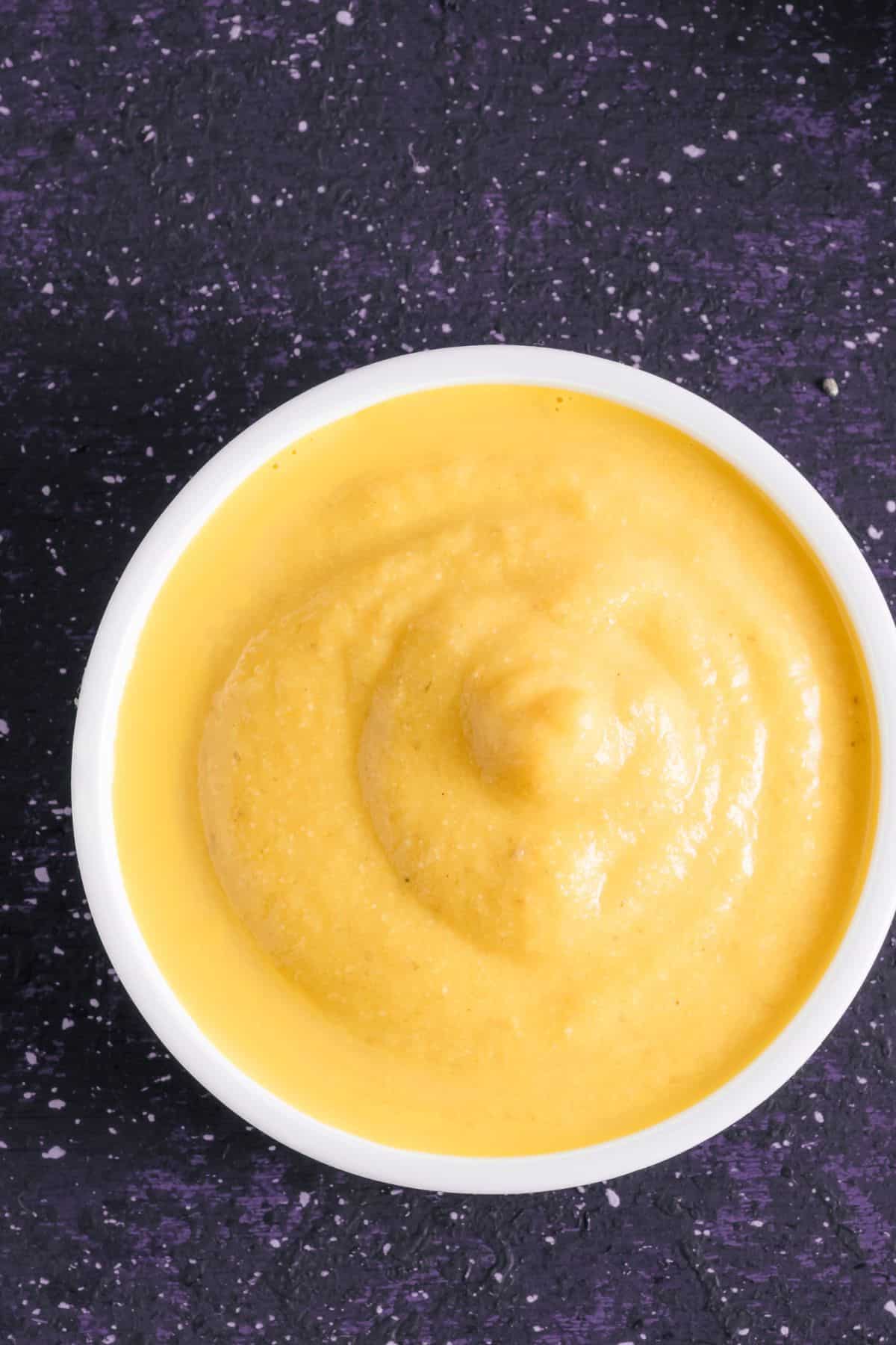 Bowl of vegan cheese sauce on countertop.