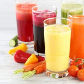 five glasses of different types of juice.