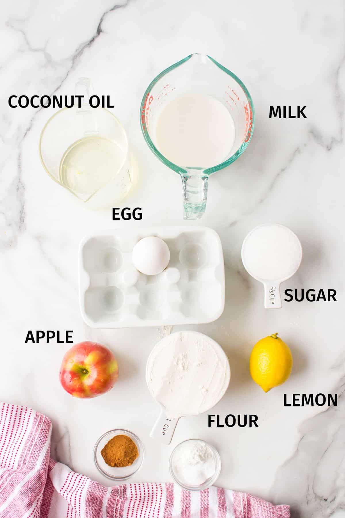 Ingredients to make gluten-free apple muffins on a white surface.