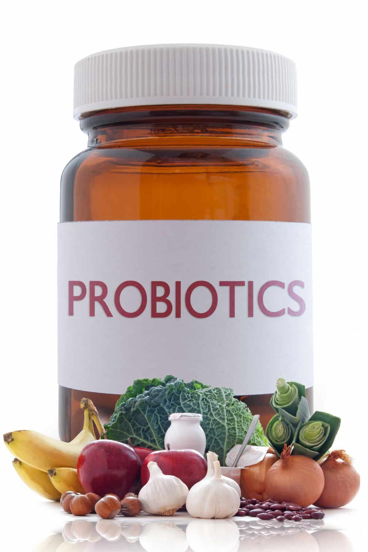a bottle of probiotics surrounded by healthy foods.