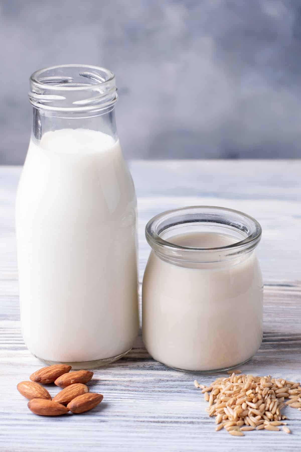 a jar of almond milk beside a cup of rice milk.