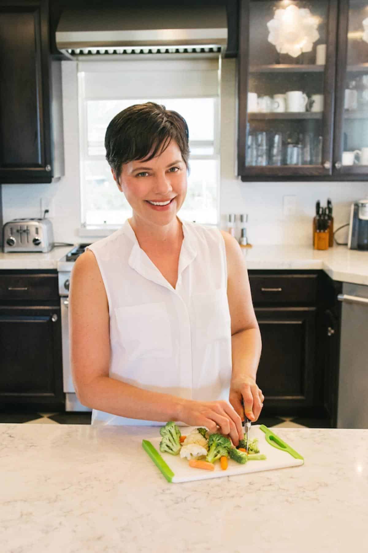 carrie cutting veggies in kitchen.