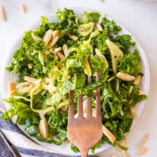 A forkful of kale salad over a serving bowl.