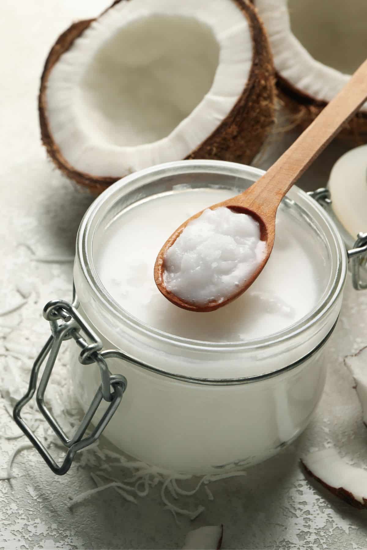 Jar of coconut cream with halved and shredded coconut.