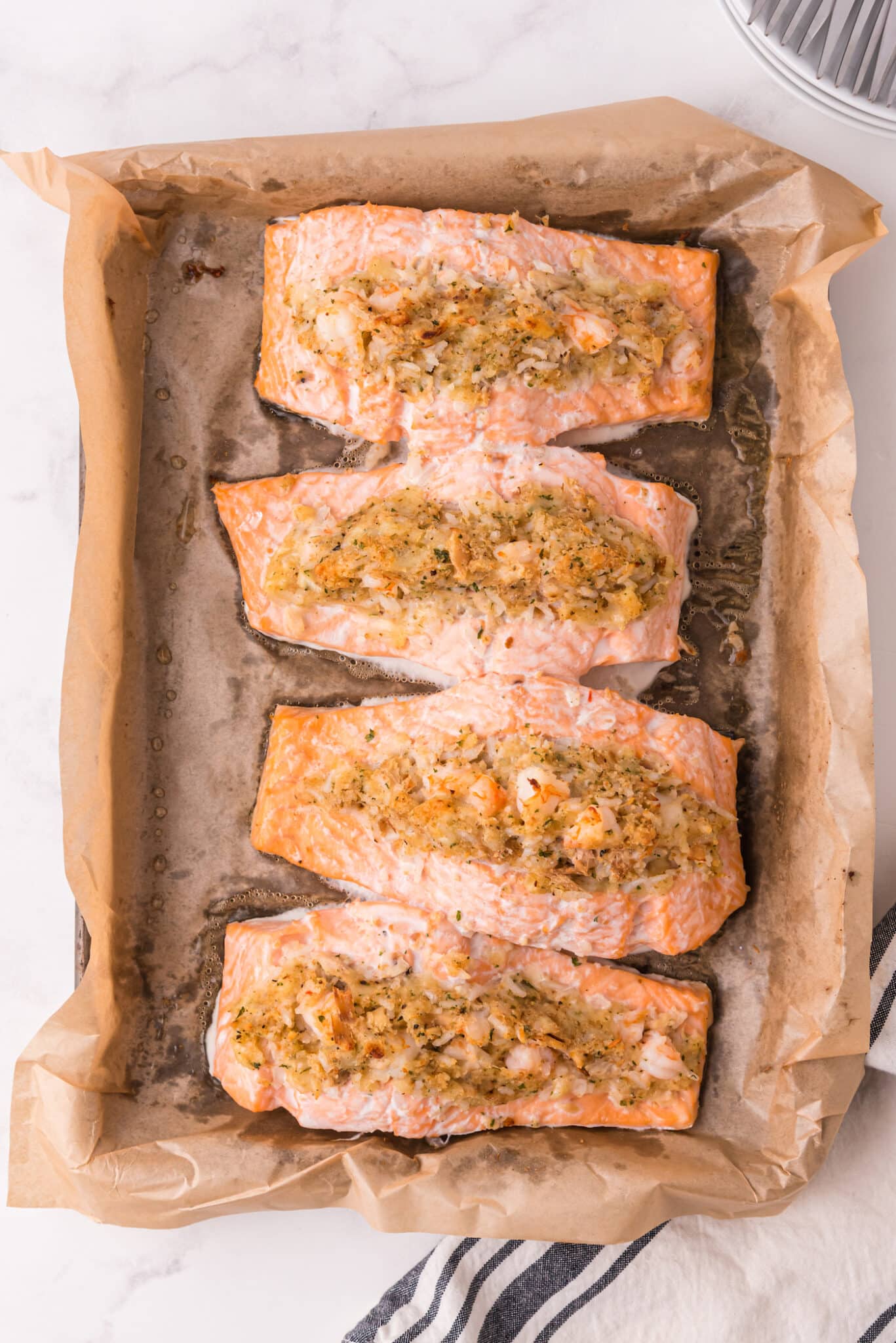 Baked, stuffed salmon filets in a parchment lined baking dish.