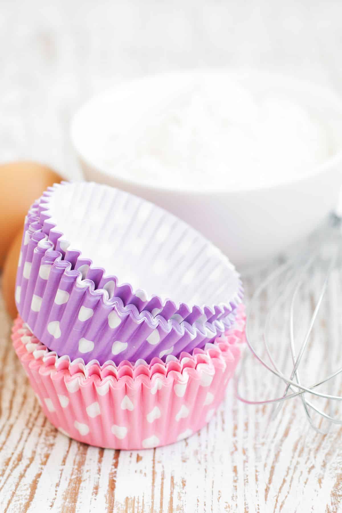 Pink and purple cupcake papers in a stack.