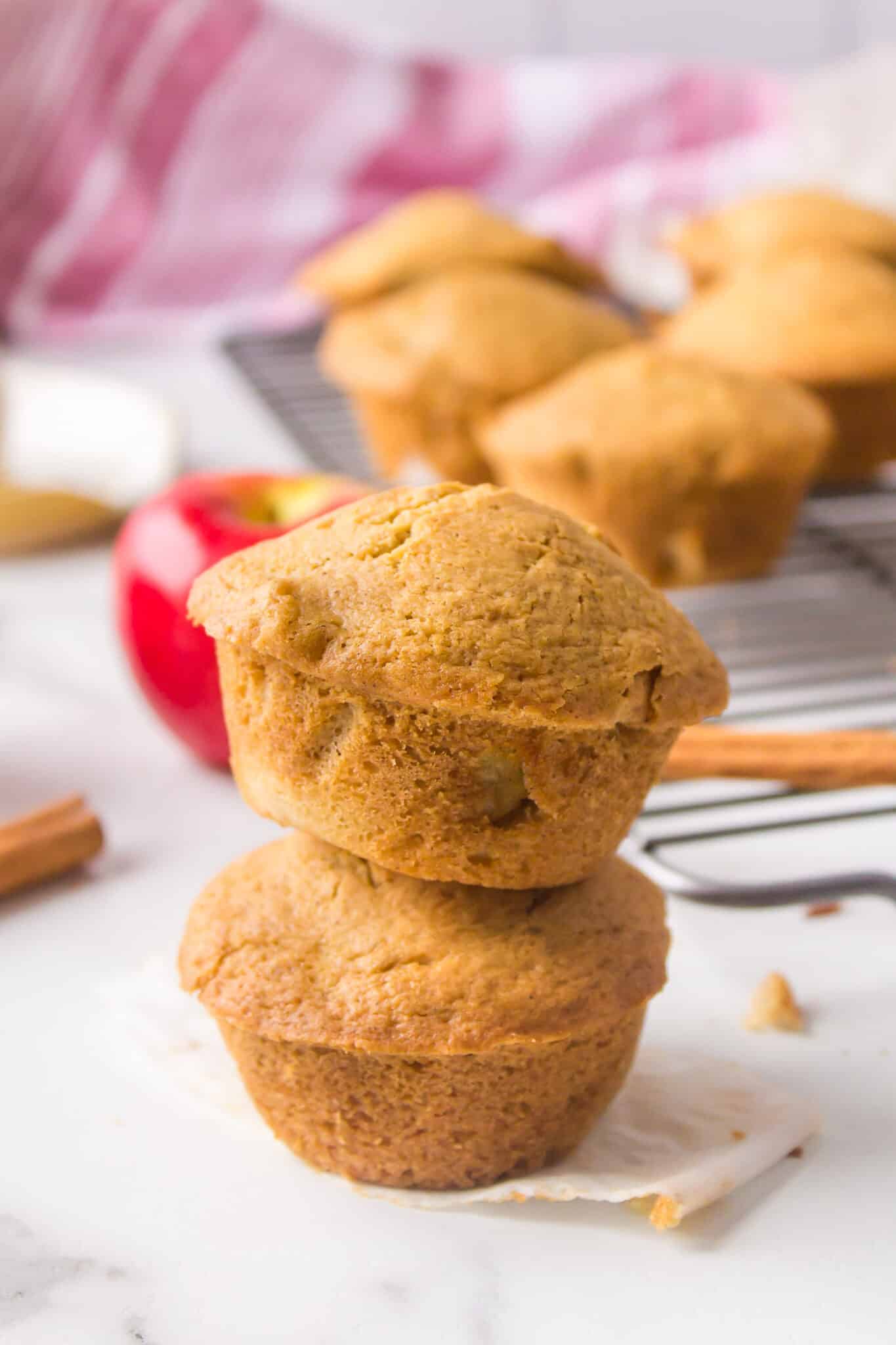 Two gluten free apple muffins stacked on a counter.