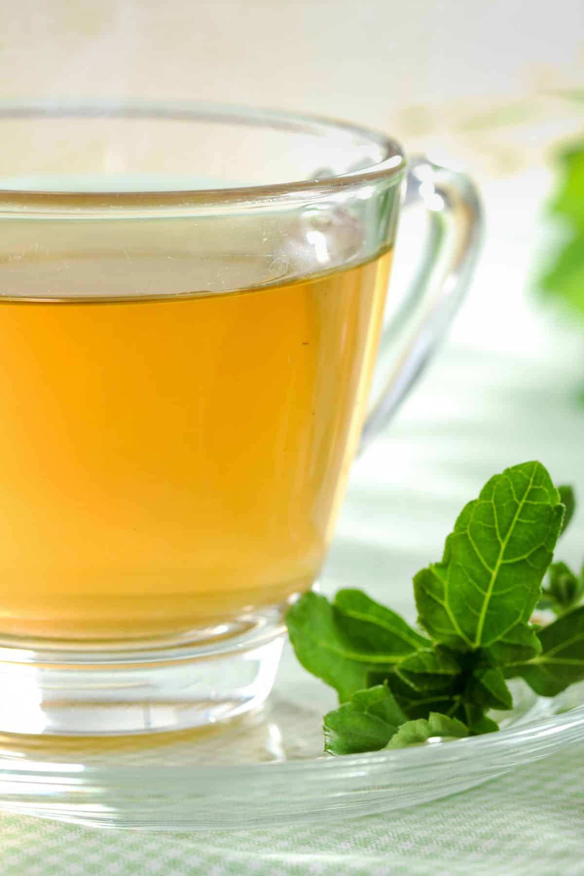 a clear glass cup of green tea.