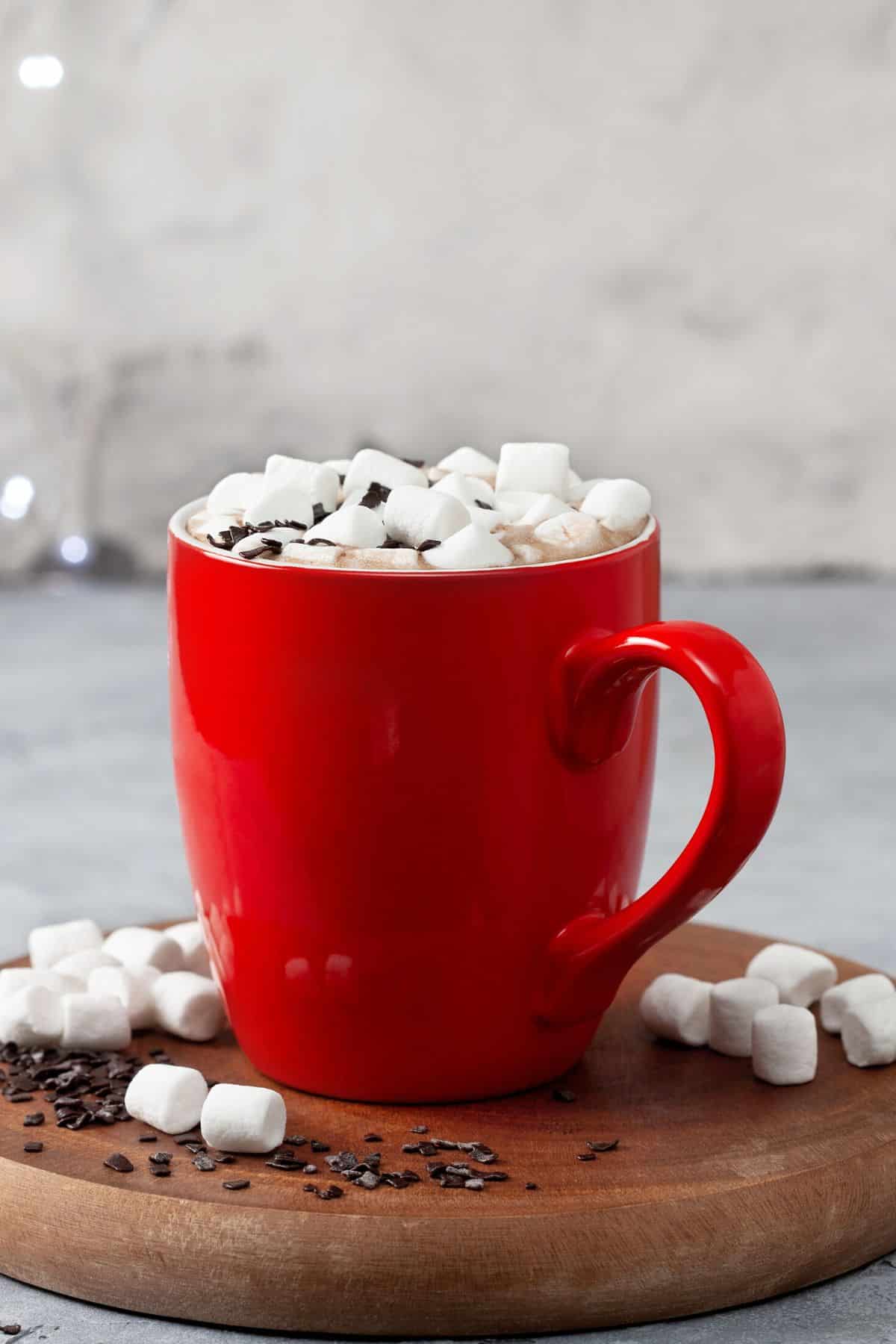 A red mug of hot chocolate topped with mini marshmallows.