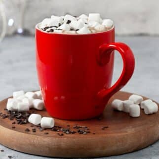 A red mug of hot chocolate topped with mini marshmallows.