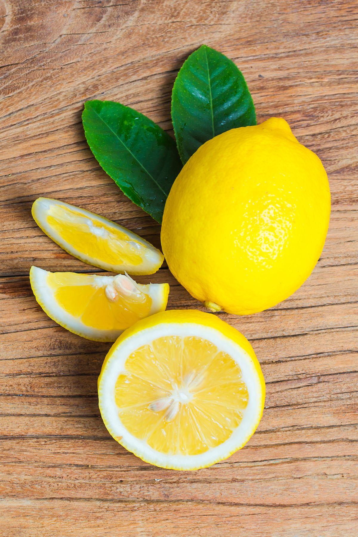 a whole and sliced lemon on a wooden table.