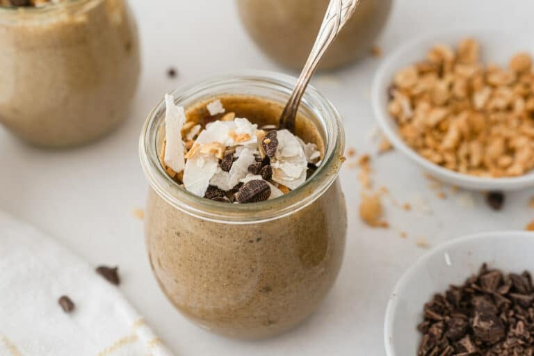 Small jars of PB chia pudding topped with chocolate and coconut.