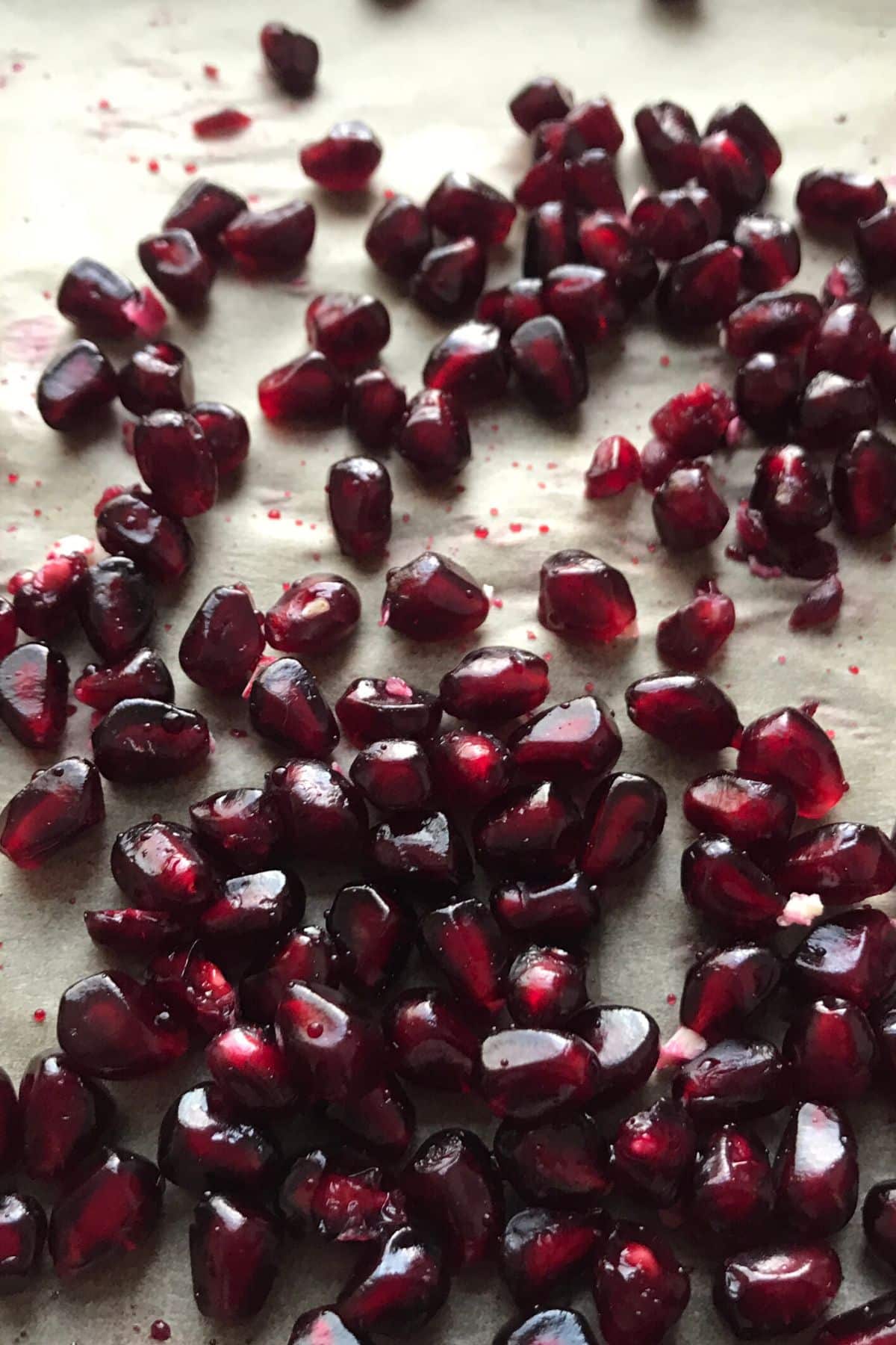 Deep, dark pomegranate arils on a white background.