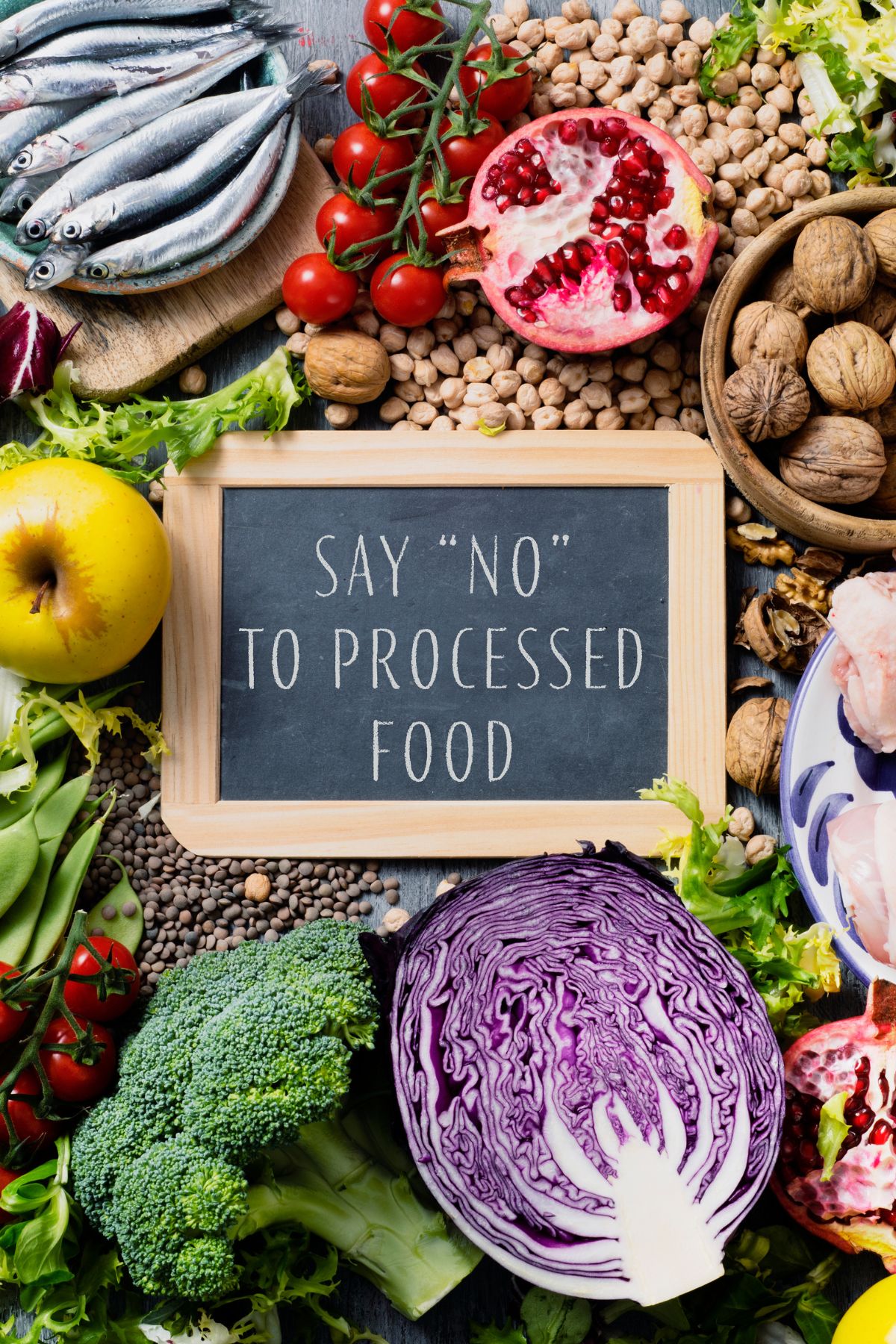 a sign reading "say no to processed food" laying in the middle of healthy foods.