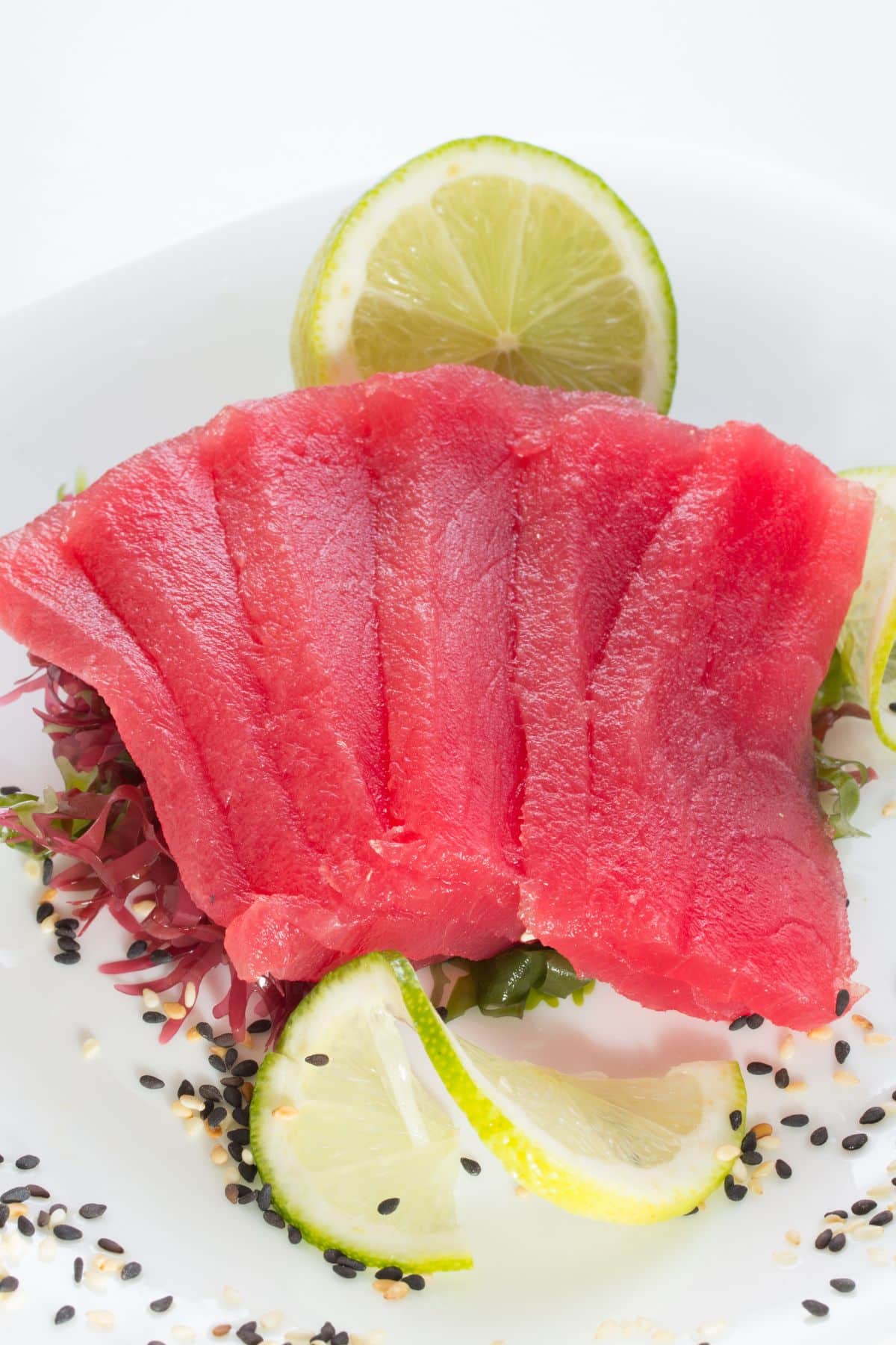 Slices of tuna fillet with lime and sesame seeds.