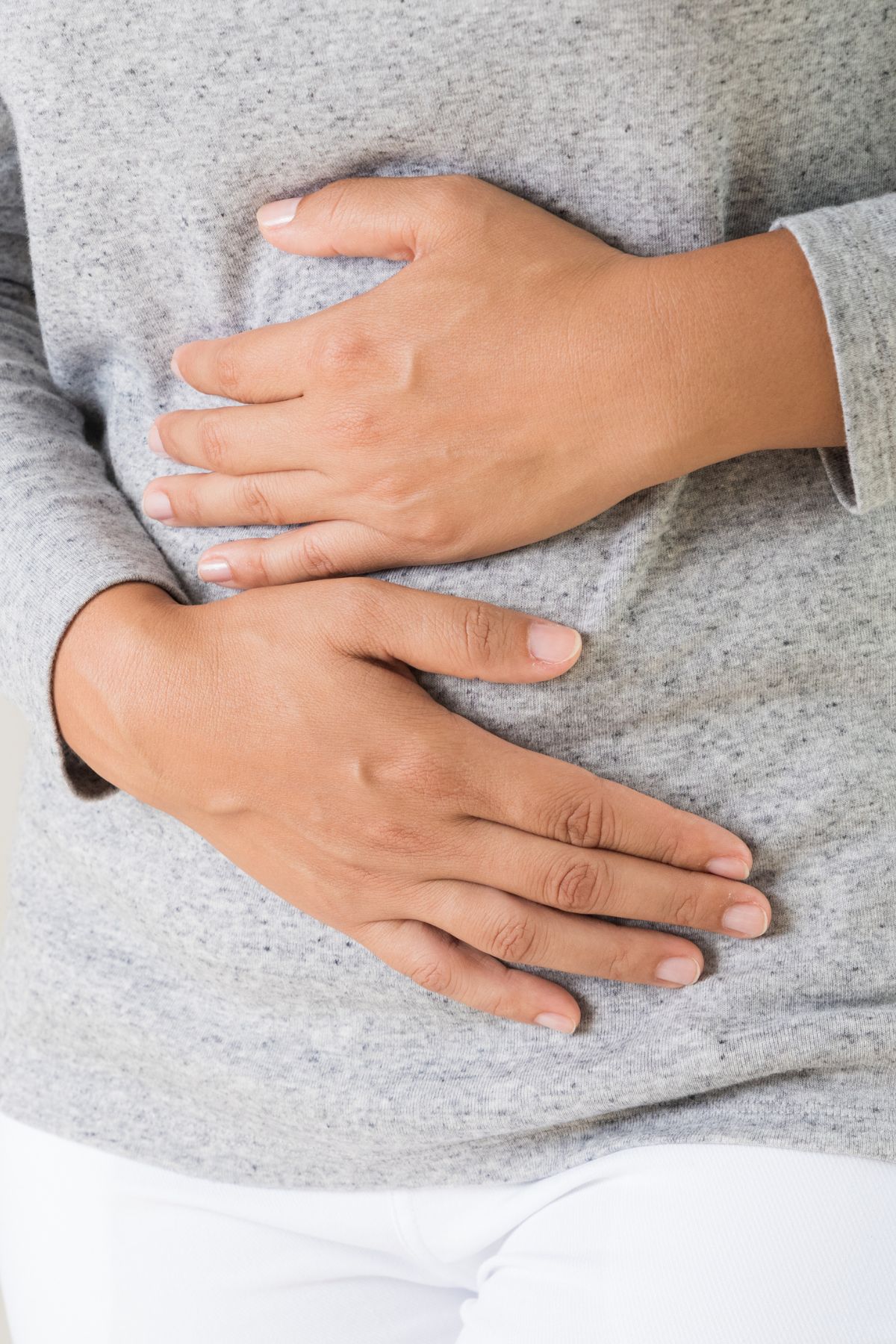 a woman holding her abdomen.