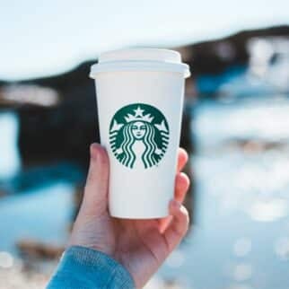 a person holding a Starbucks cup.