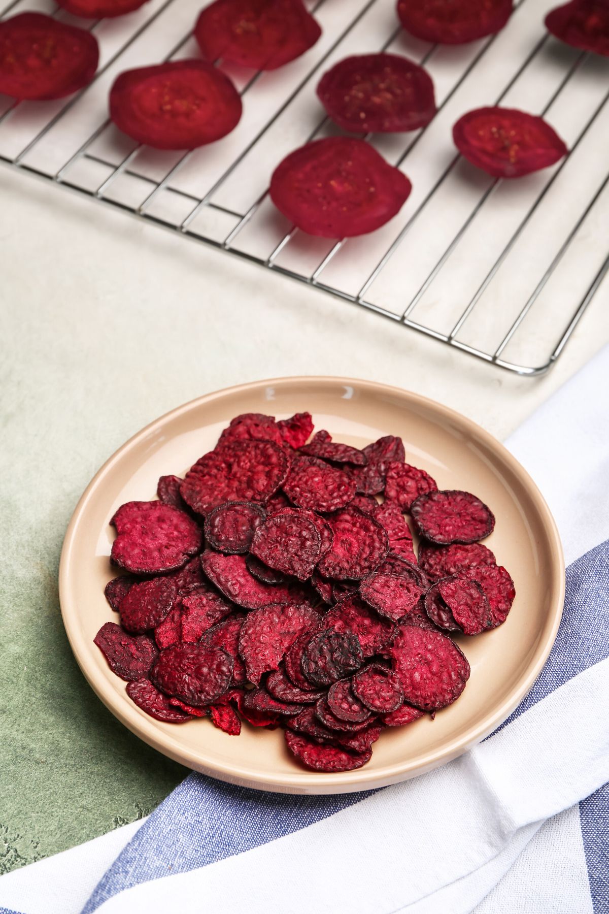 Dehydrated beet chips on a brown plate.