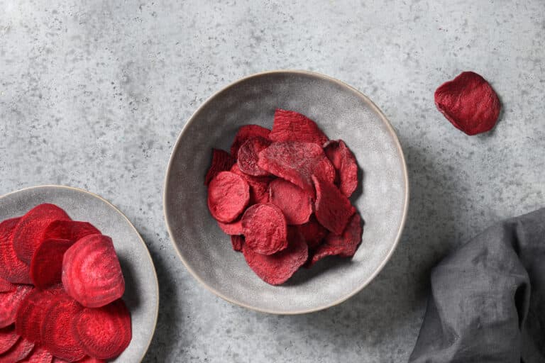 Dehydrated beet chips in two gray bowls.