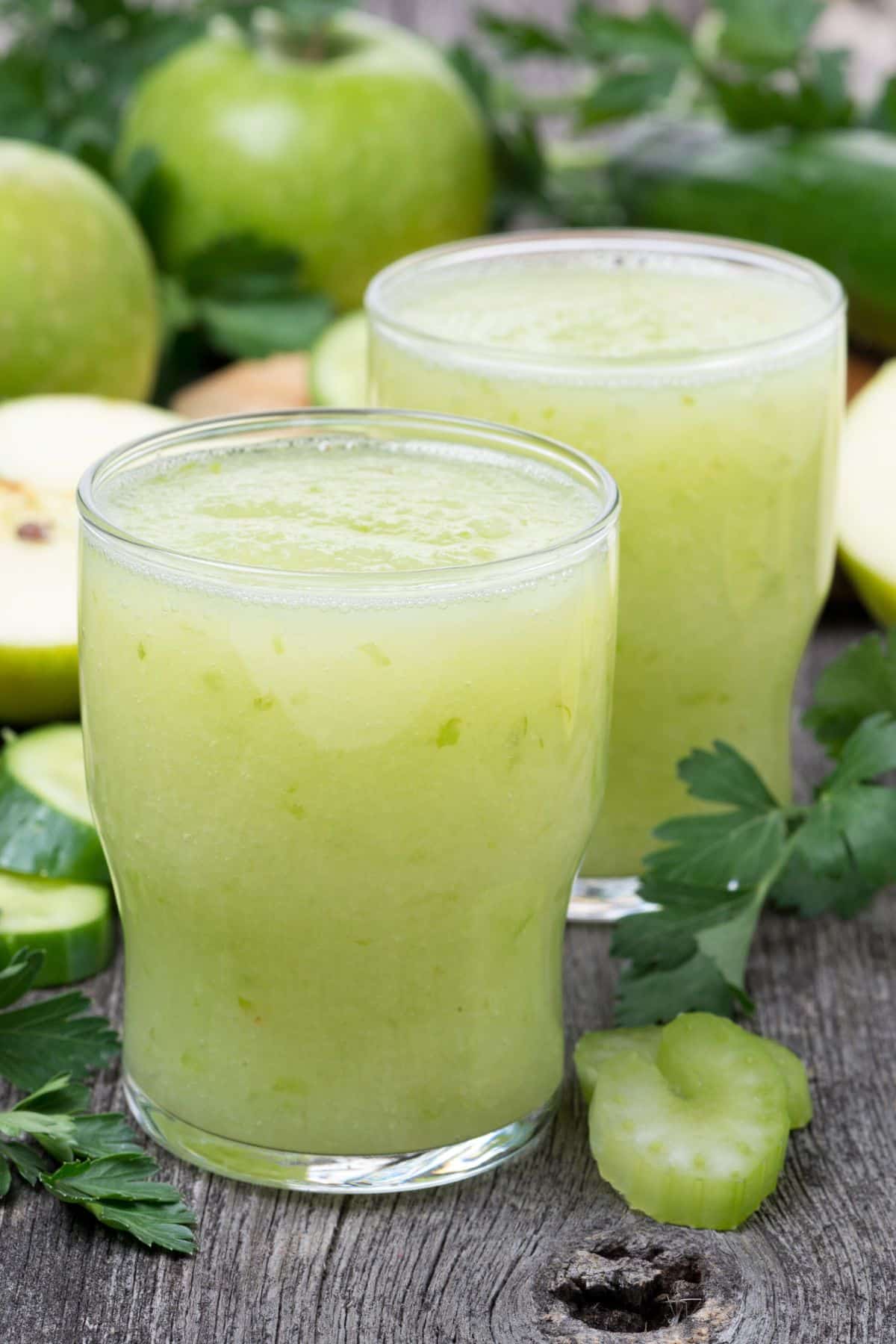 Two short glasses of light green apple celery juice.