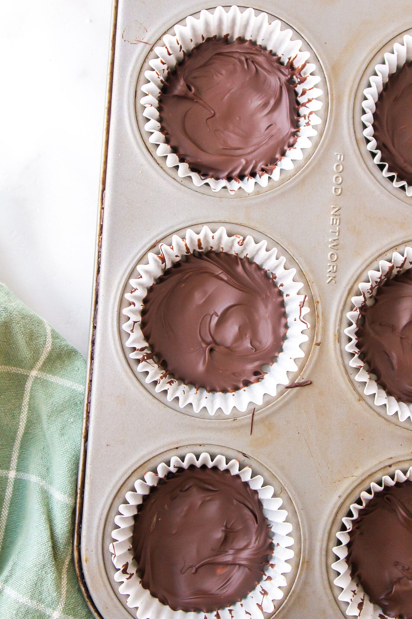 Vegan peppermint patties chilling in a muffin tin.