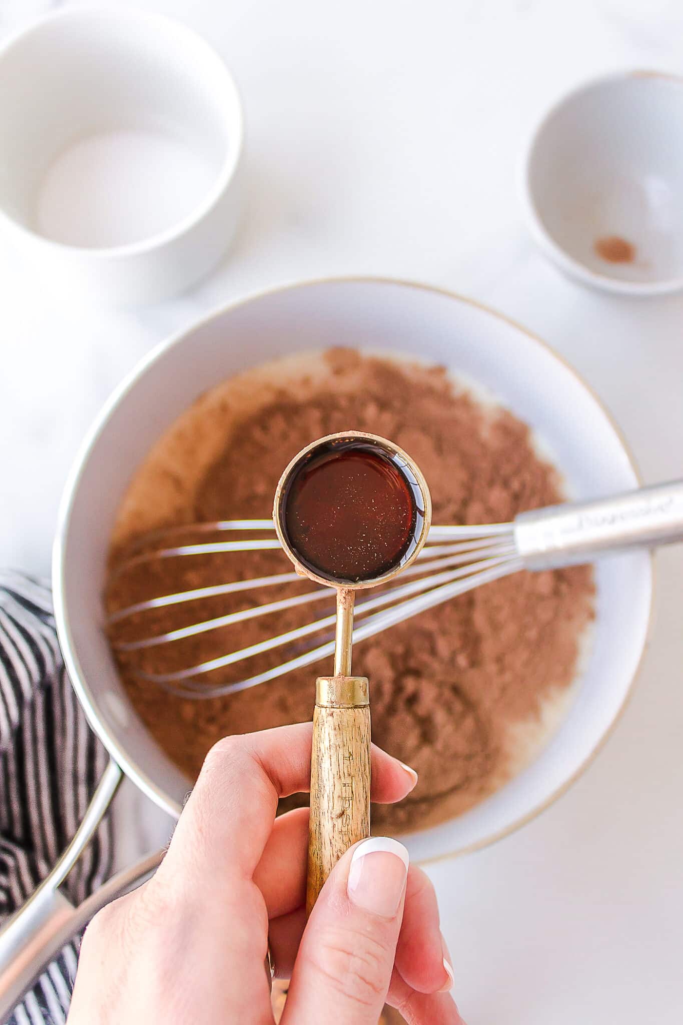 adding maple syrup to hot chocolate ingredients.