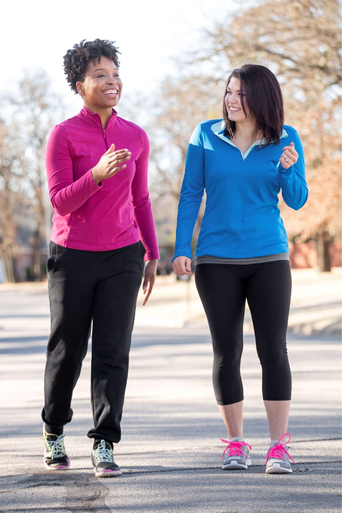 two women walking together outside.