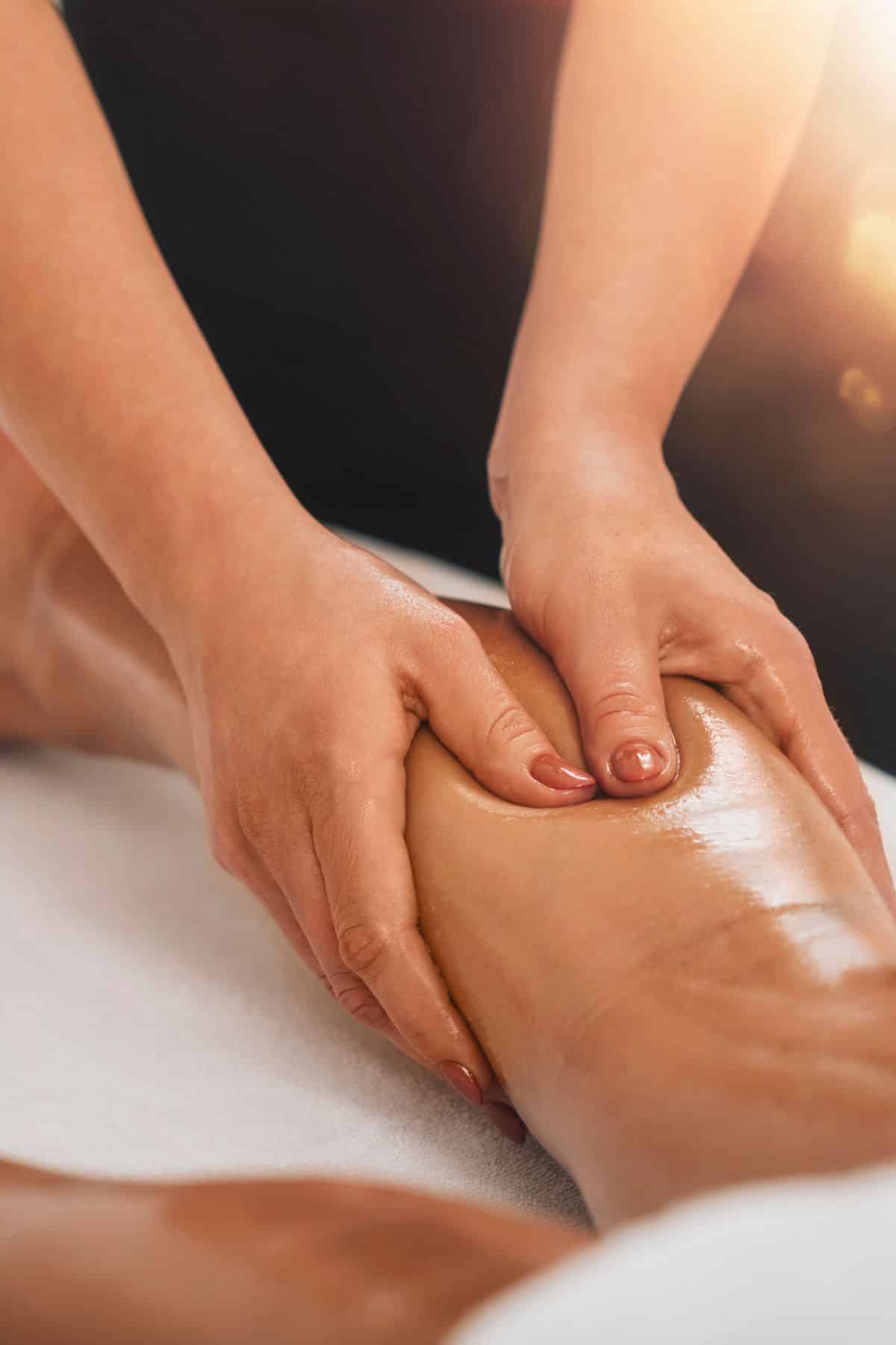 a person massaging someone's leg.