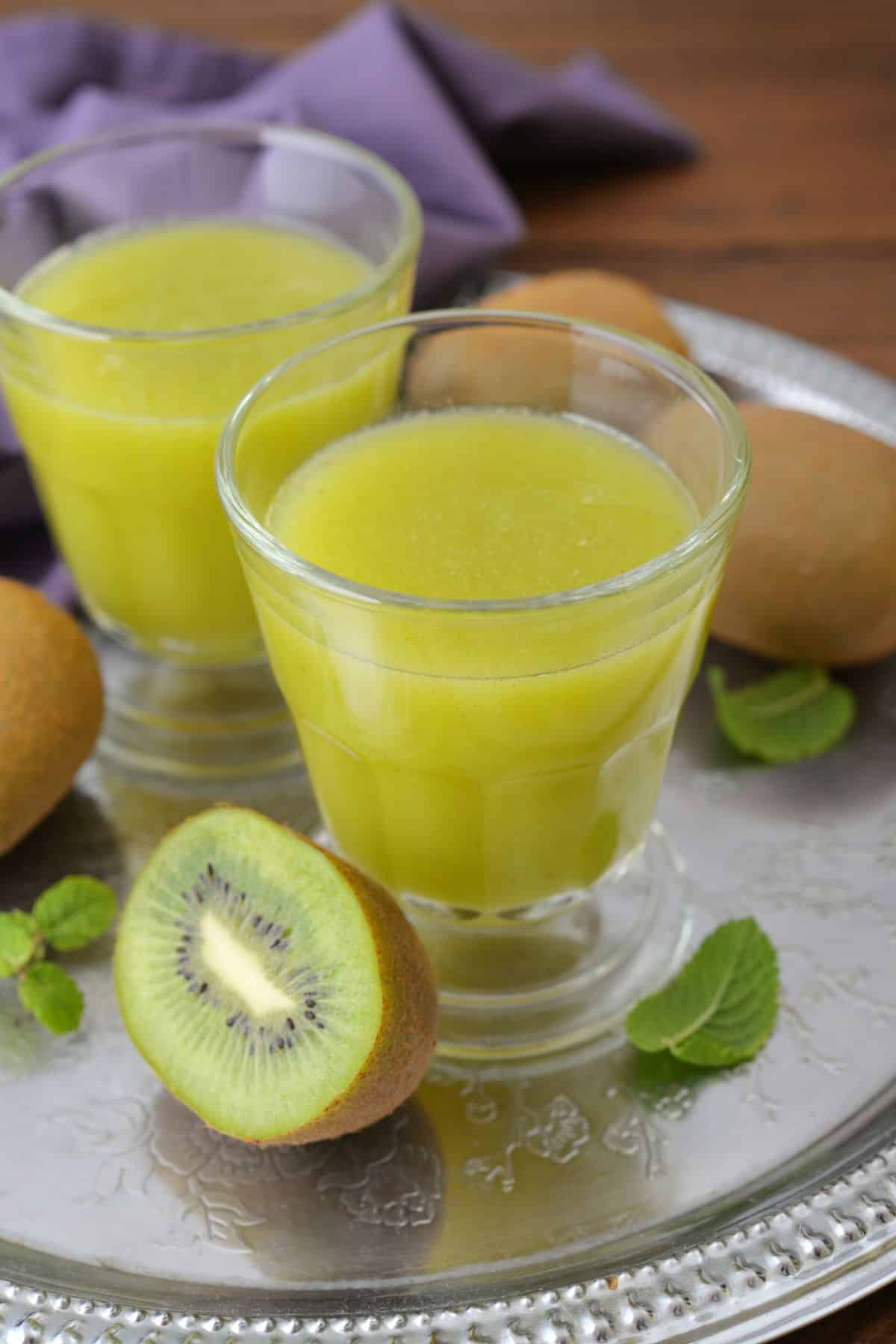 Two short glasses of freshly squeezed kiwi juice.