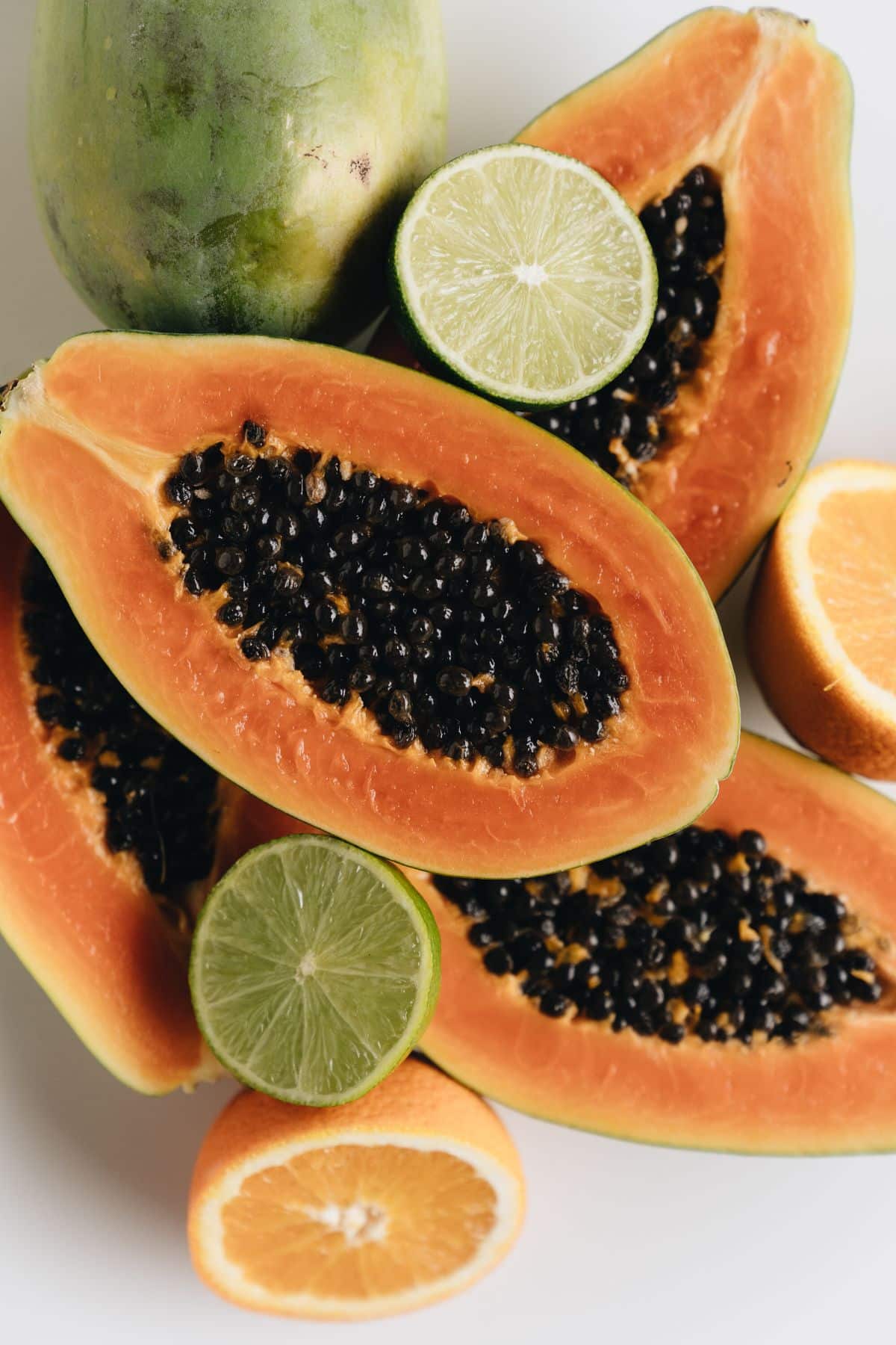 Halved papaya fruits with citrus.