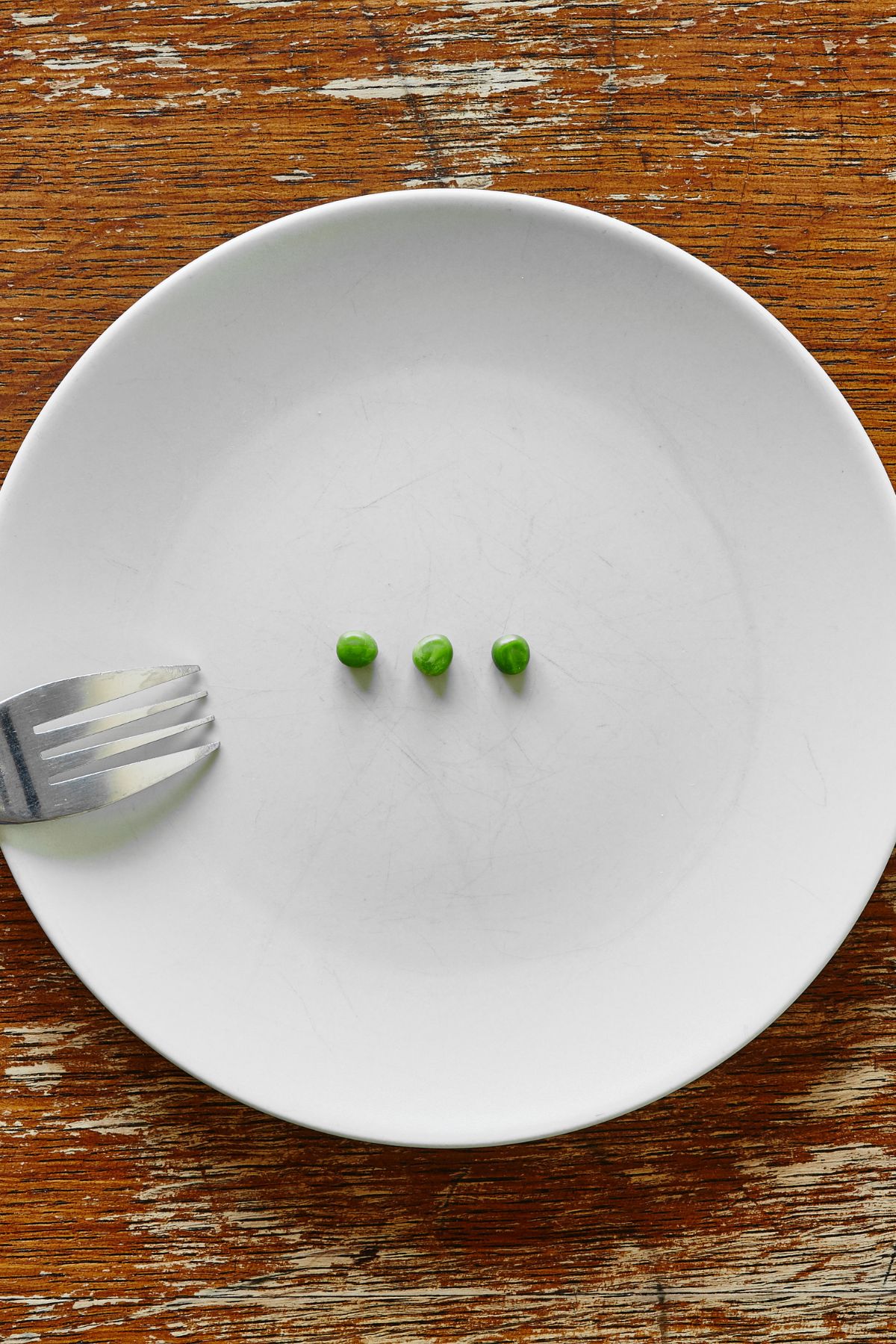 a small portion of peas on a white plate.
