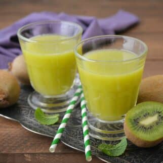 Two short glasses of freshly squeezed kiwi juice.