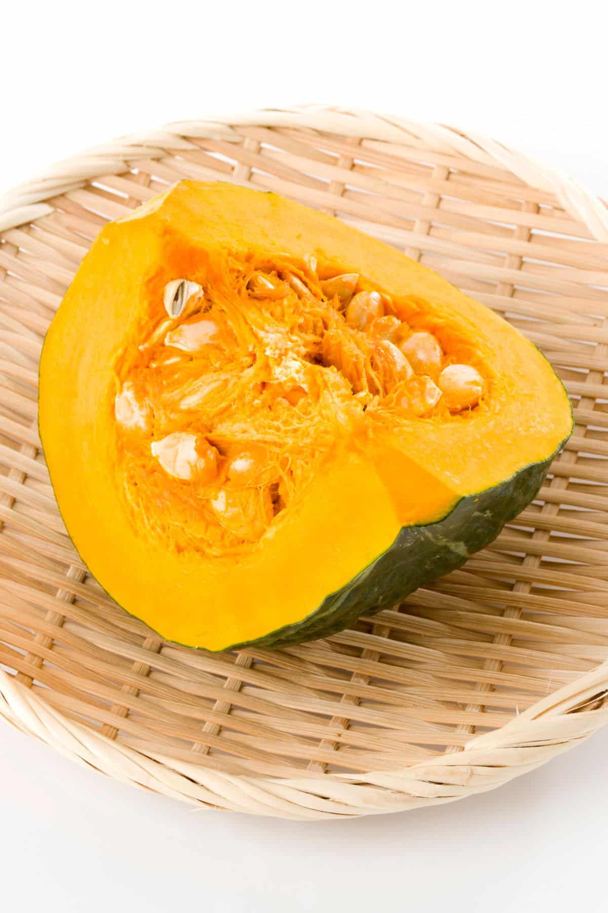 a slice of a kabocha squash in a woven bowl.