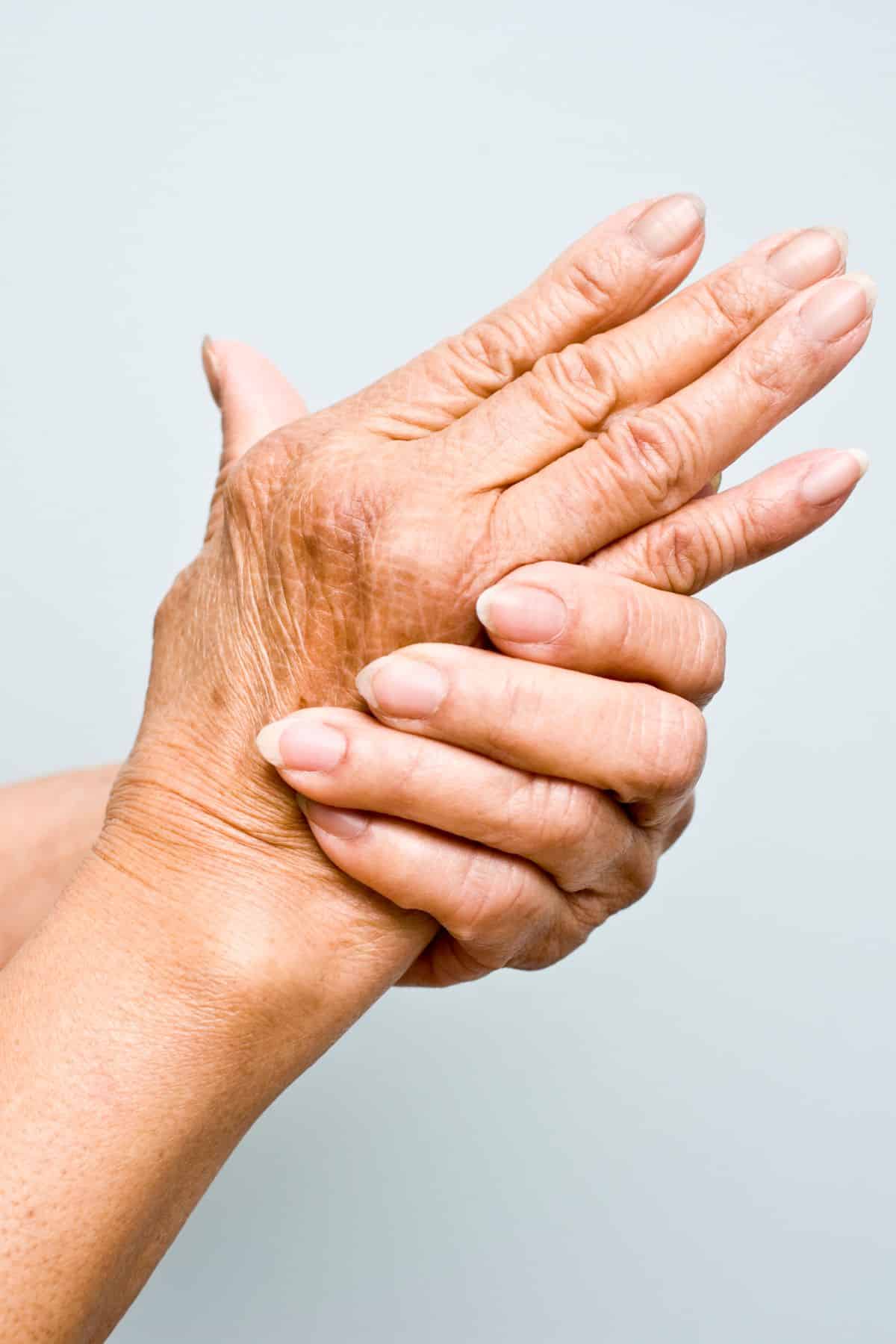 a woman holding her aching hand.