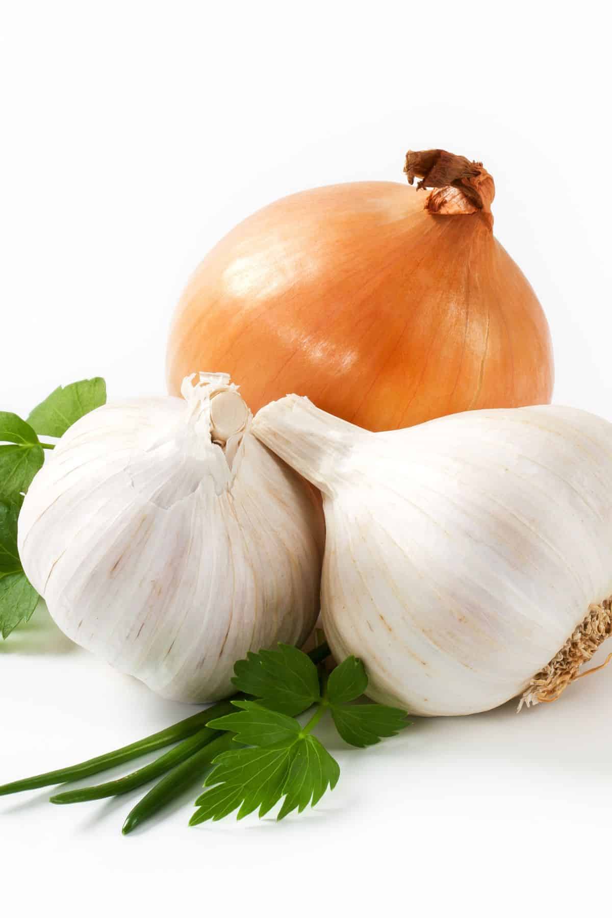 garlic and onion on a white table.