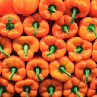 a stack of orange bell peppers.