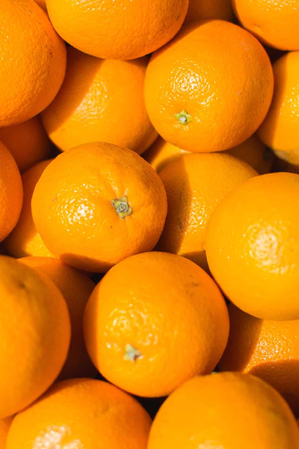 Fresh oranges covering a surface.