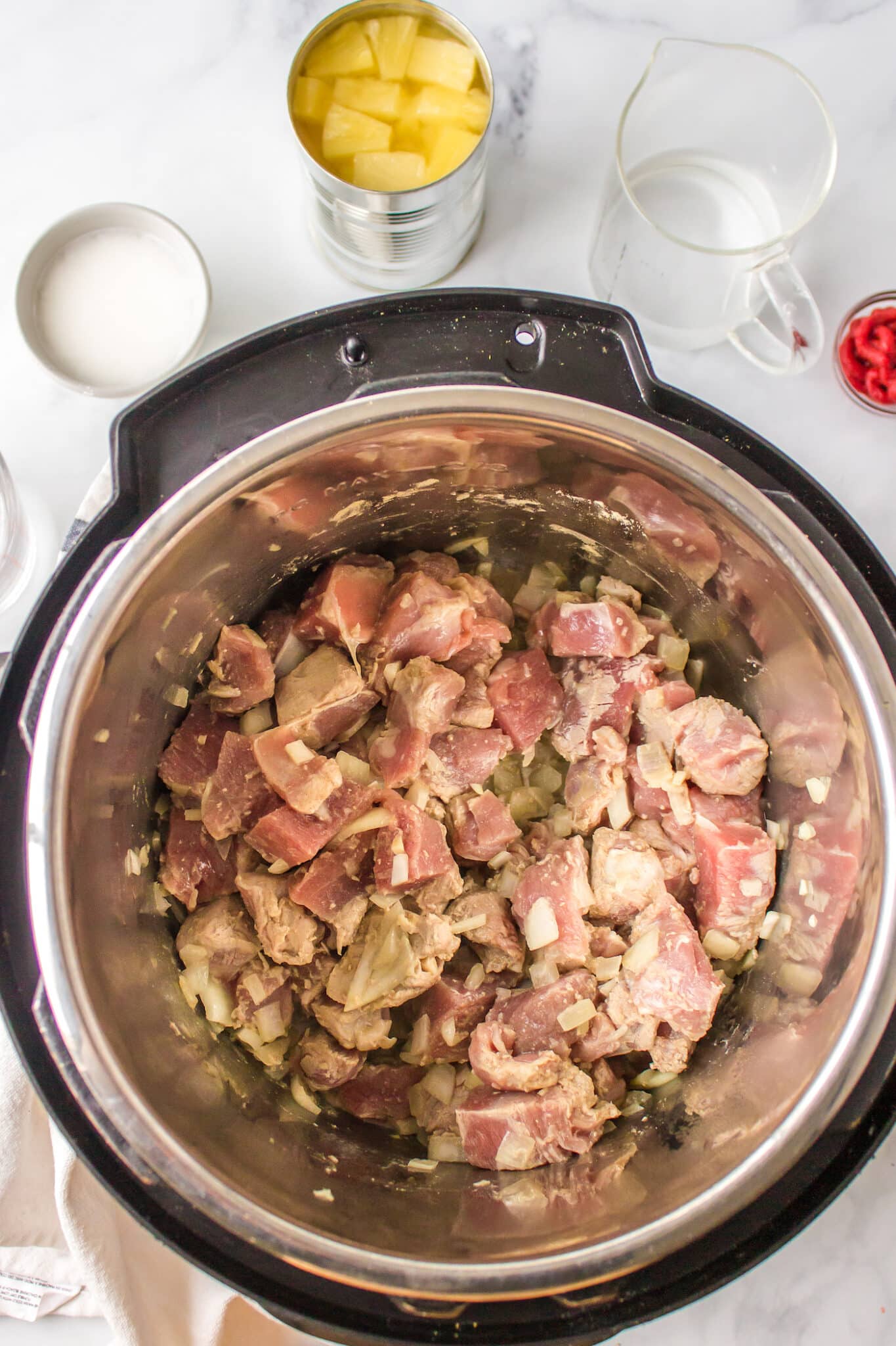 Pork cubes being browned in the liner of an Instant Pot.