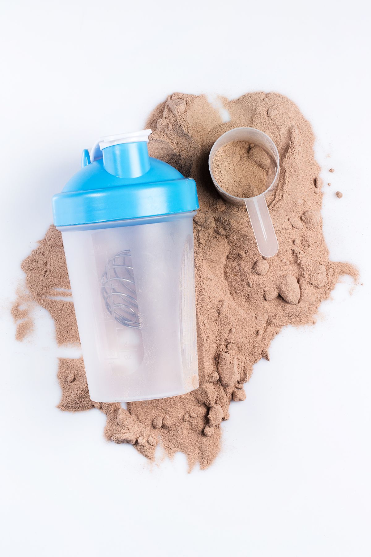 a shaker bottle and a scoop of powder on top of a mound of protein powder.