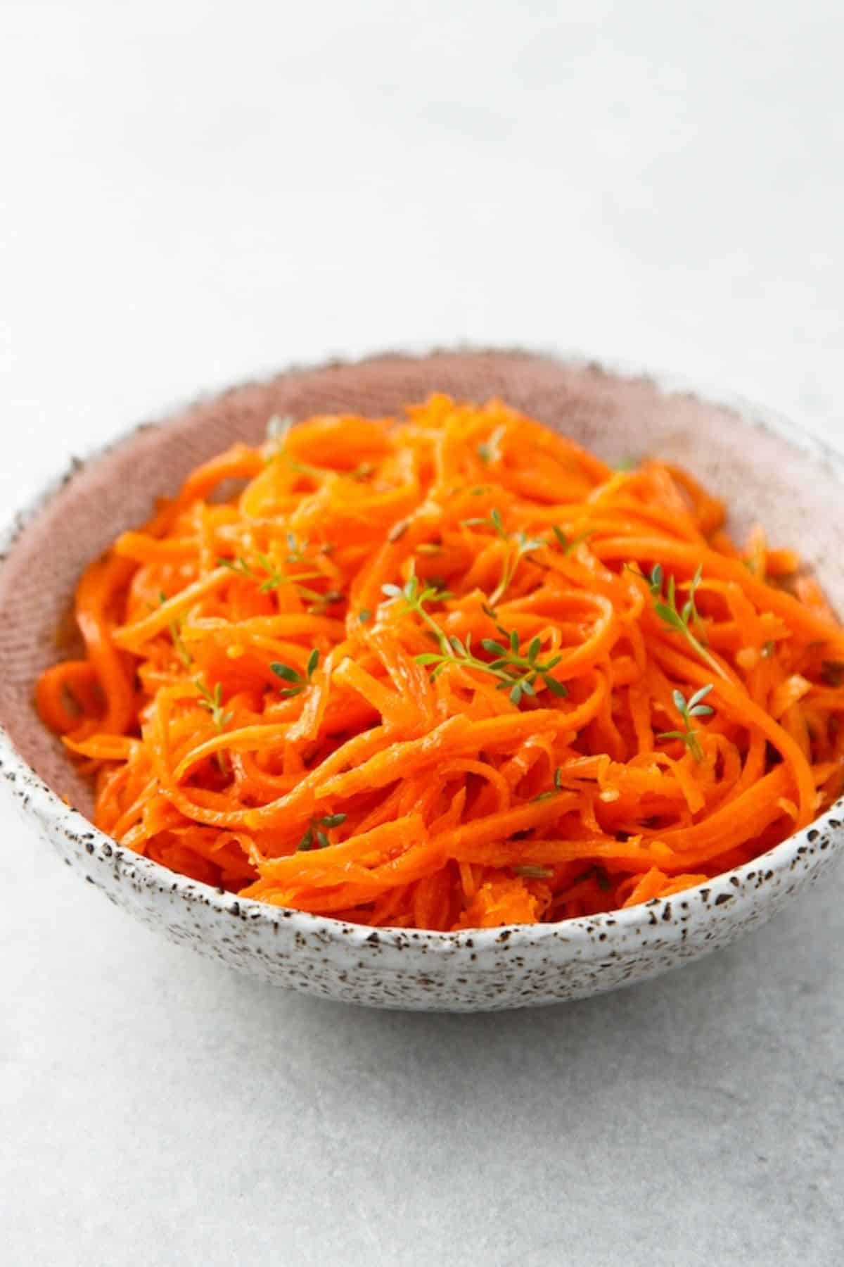 Shredded raw carrot salad topped with thyme.