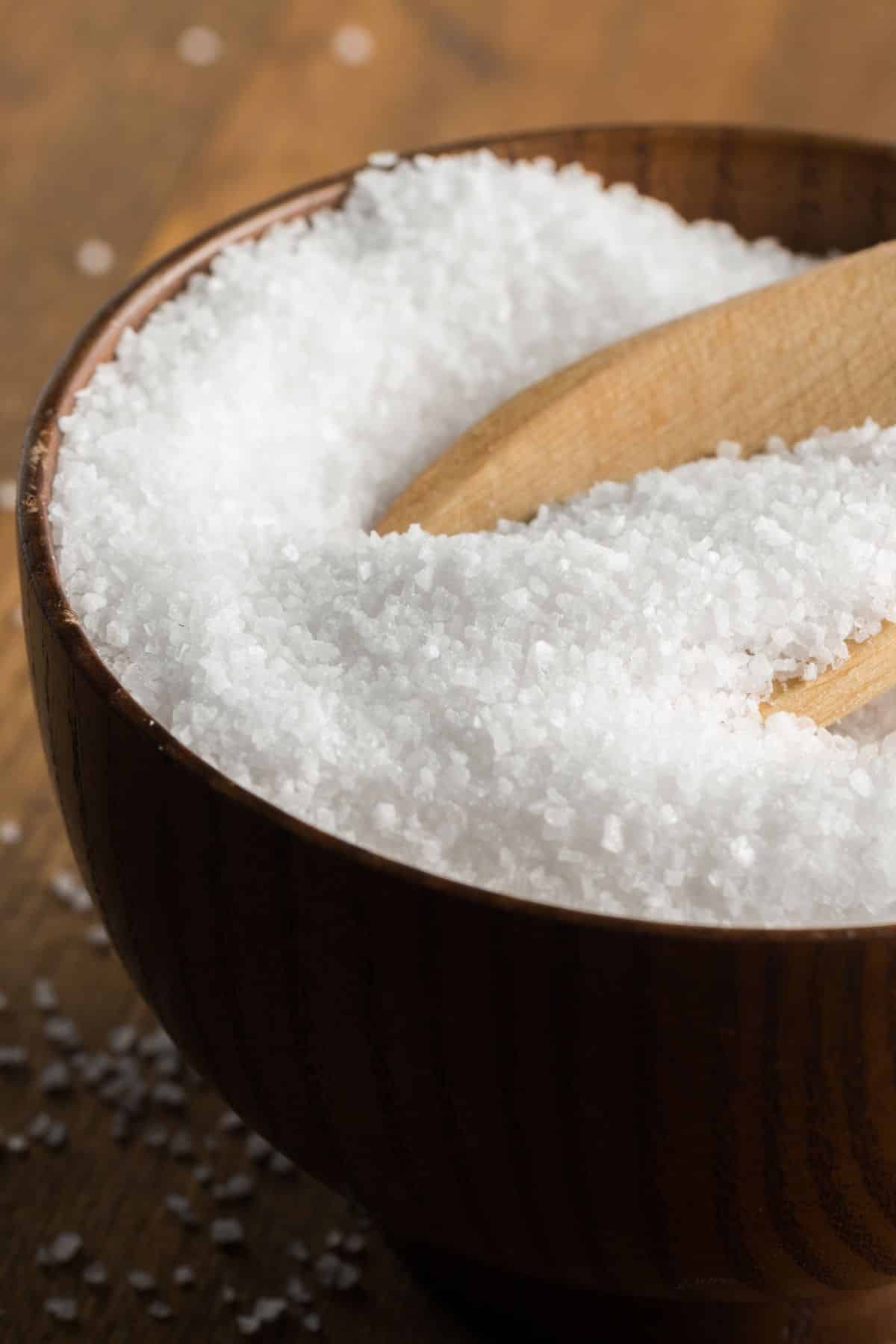 a wooden spoon in a bowl of salt.