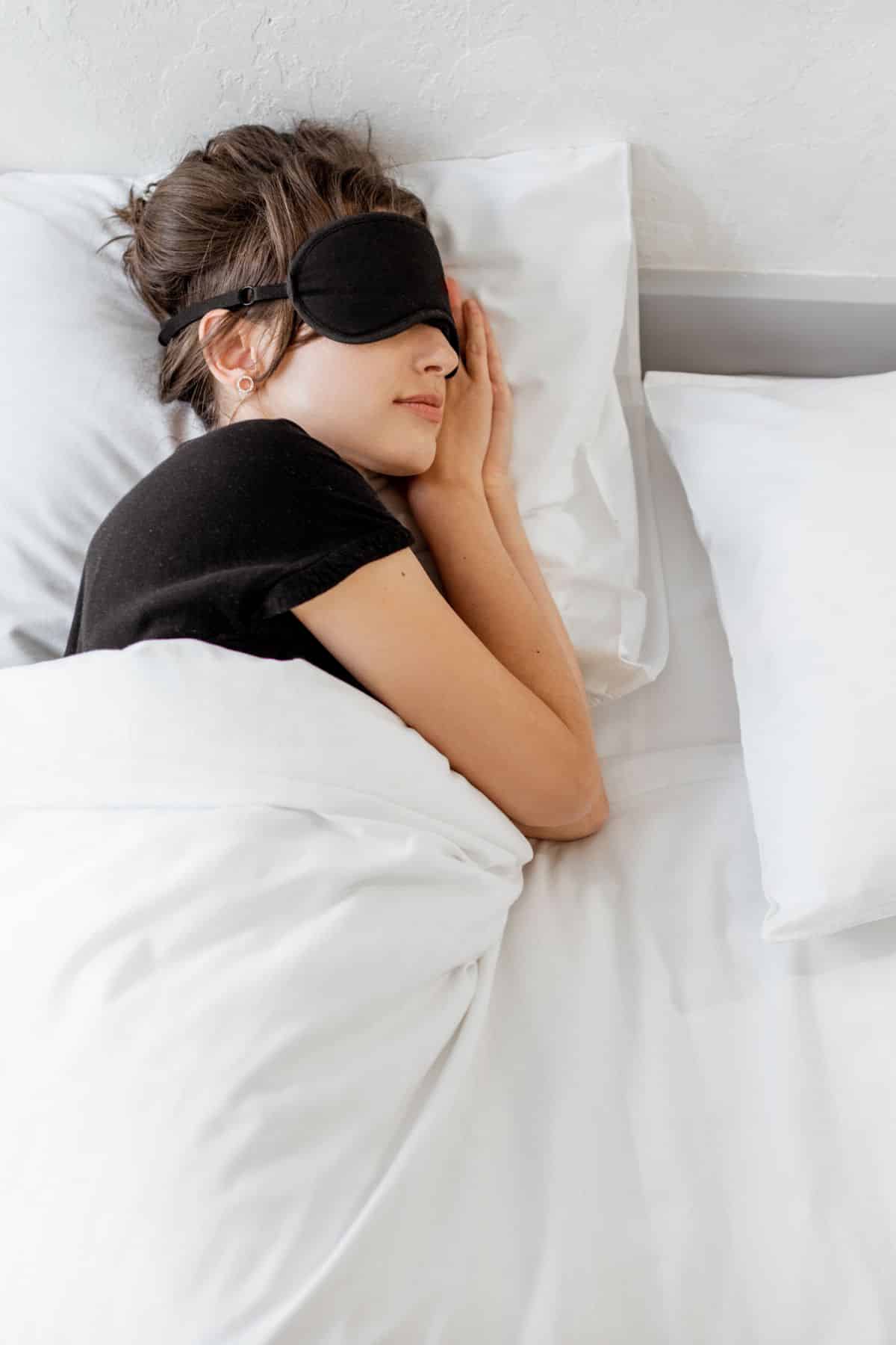 a woman sleeping with an eye mask on.